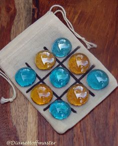 four blue and yellow glass beads are on a white cloth with drawstrings