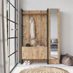 a wooden bench sitting in front of a mirror next to a rug on the floor