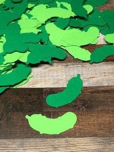 green paper cut out to look like vegetables on a wooden table with scissors and glue