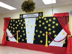 a decorated stage with red drapes and yellow stars