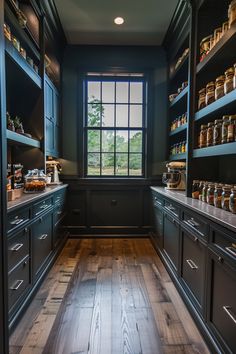 an empty kitchen with wooden floors and blue painted cabinets, along with shelves filled with food