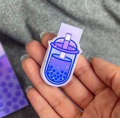 a person holding a purple and blue sticker in their left hand with bubbles on it