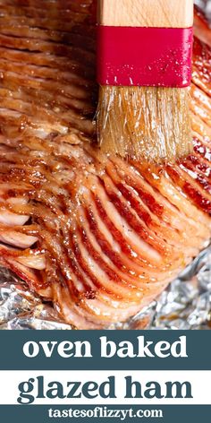 a close up of a piece of meat on tin foil with a brush in it