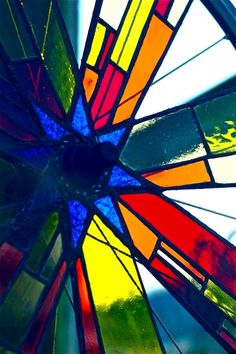 a colorful stained glass window in the shape of a wheel