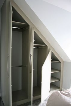 an attic bedroom with two closets in it