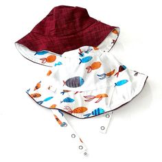 Please visit our website for more selection. Quite possibly the cutest maritime bucket EVER.  Sweet little swimming fish reverse to a gorgeous, deep ruby red slub woven chambray.  Together, these fabrics are pure perfection.  UPF 50+, of course. * Did you know ALL of our hats are rated UPF 50+? Our exclusive full circle sun protection-- along with a UPF 50+ rating-- makes our buckets superior to others. Plus, they're reversible! The straps slide through slots so you can use BOTH sides! ROCK ON! Playful Red Summer Hat, Red Cotton Sun Hat For Spring, Red Cotton Summer Hats, Reversible Cotton Sun Hat For The Beach, Urban Baby, Red Fish Blue Fish, Beach Play, Wooly Hats, Swimming Fish