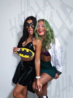 two women dressed up as batman and catwoman posing for the camera with each other