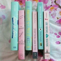 five books lined up on top of each other in front of a flowered sheet