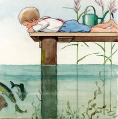 a child laying on top of a wooden bench next to a body of water with fish