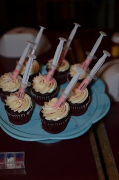 some cupcakes with toothbrushes on them are sitting on a blue plate