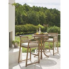 an outdoor table and chairs on a patio with trees in the background