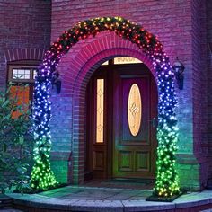 an entrance to a house decorated with christmas lights and wreaths on the front door