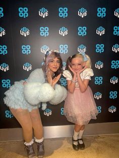 two girls dressed in costumes posing for the camera