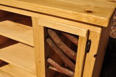 a close up of a wooden cabinet with some wood sticks in the bottom drawer and one piece of wood sticking out of it