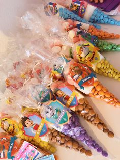 there are many candy cones and candies lined up on the counter top, including one for children's birthdays