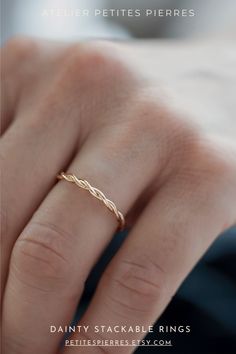 a woman's hand with a gold ring on her finger, and the words dainty stackable rings written below it