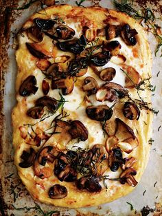 a square pizza with mushrooms and cheese on a sheet of baking paper, ready to be eaten