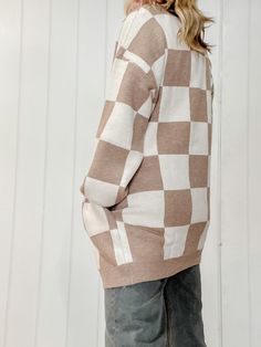 Introducing our Checker Graphic Sweater Cardigan, a versatile and stylish addition to your wardrobe. This cardigan seamlessly combines comfort and fashion with its soft, knit fabric and eye-catching checker graphic design. The classic cardigan silhouette makes it easy to layer over your favorite outfits, while the bold checker pattern adds a trendy and modern touch. Cozy Checkered Cardigan Regular Fit Pockets Open Cardigan Long Sleeve 68% Rayon, 32% Nylon Machine wash cold, gentle cycle, tumble Casual Plaid Sweater For Layering, Plaid Cotton Sweater For Fall, Plaid Sweater For Fall, Casual Beige Jacquard Knit Cardigan, Trendy Plaid Long Sleeve Cardigan, Casual Long Sleeve Argyle Outerwear, Casual Argyle Pattern Top For Fall, Fall Jacquard Knit Cardigan For Layering, Oversized Plaid Spring Cardigan