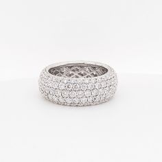 a white gold ring with rows of round brilliant cut diamonds set in the center, on a plain surface