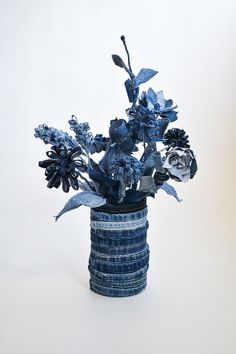 a blue vase filled with flowers on top of a white table