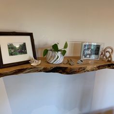 a wooden table topped with pictures and frames