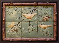 decorative tile with birds on branches and leaves inlayed to wood frame, painted green