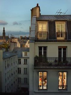 an apartment building with many windows and balconies on the top floor at dusk