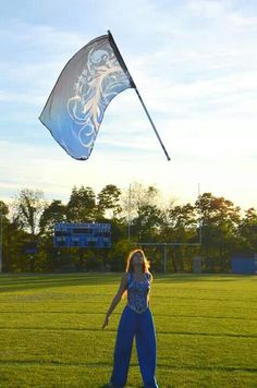 a woman is flying a kite on the field