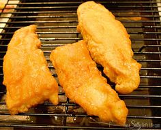 three pieces of chicken cooking on a grill