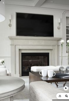 a living room filled with furniture and a flat screen tv mounted above a fire place