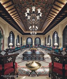 an ornately decorated lobby with chandelier and seating area in the center, surrounded by large windows