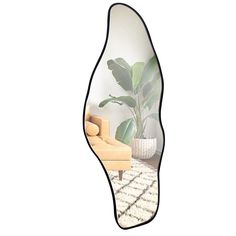 a mirror with a plant in it and a chair next to it on a rug