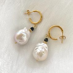 Elegant baroque pearl drop earrings made of beautiful baroque fresh water pearls, black Spinel, diamond pave accent beads and gold plated silver hoops. MATERIALS: Hoops measure 15 mm. Pearls measure around 16X20 mm Drop length 30mm All our earrings will be sent to you with extra silicon backs Handmade in Canada. Comes in a gift box and a complementary pouch. 🎁🔖BUY MORE SAVE MORE🎁🔖 Buy 2 Items Get 10% automatic Discount at Checkout or Copy Paste Promo Code 👉BUY2SAVE10👈 Buy 3 Items Get 12% Discount With Promo Code 👉BUY3SAVE12👈Copy/Paste the code at checkout Buy 4 Items & More Get 15% Discount With Promo Code 👉BUY4SAVE15👈Copy/Paste the code at checkout Drop Earrings Gold, Pearl Hoop Earrings, Water Pearls, Black Spinel, Copy Paste, Pearl Drop Earrings, Baroque Pearls, Silver Hoops, Pearl Drop