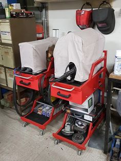 two red work benches sitting next to each other in a garage with tools on the floor