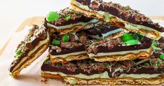 a stack of chocolate and mint covered desserts sitting on top of a piece of parchment paper