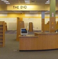 the inside of an empty book store with bookshelves and computers on tables in it