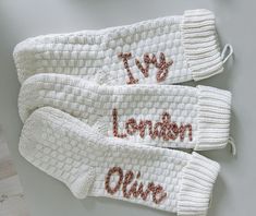 two white knitted gloves with the words london written on one side and an inscription that says i love london above them