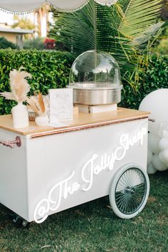 an ice cream cart with the words the juicy shop on it and balloons in the background