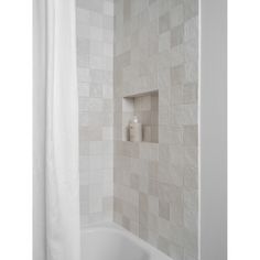 a white bath tub sitting next to a shower curtain