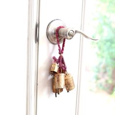 a door handle with bells hanging from it's side and some keys attached to it