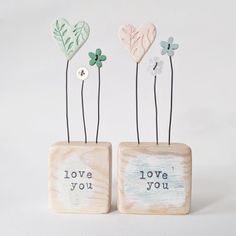 two small wooden blocks with flowers and leaves on them that say i love you, i love you