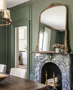 a living room with green walls and a fireplace