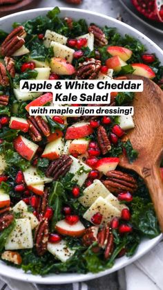 an apple and white cheddar kale salad with pecans, pomegranates, and apples