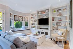 a living room filled with furniture and a flat screen tv mounted on a wall next to a window