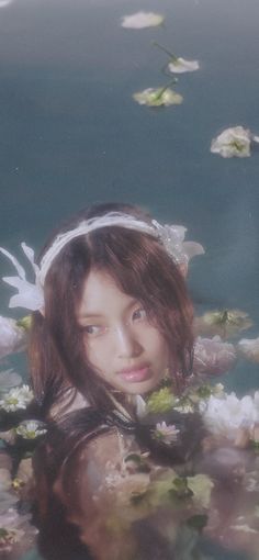 a woman with flowers in her hair standing under water