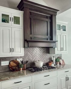 an image of a kitchen with white cabinets and gray backsplashes on the wall