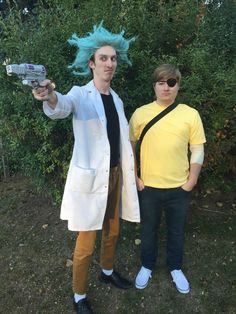 two people dressed in costumes standing next to each other and one has blue hair on his head