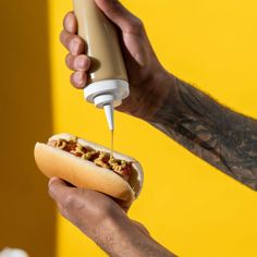 a hot dog being drizzled with mustard