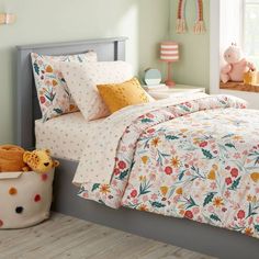 a child's bedroom with green walls and flowers on the comforter, bedding