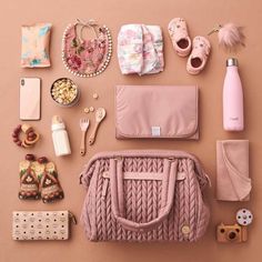 the contents of a pink purse laid out on a table next to other items and accessories